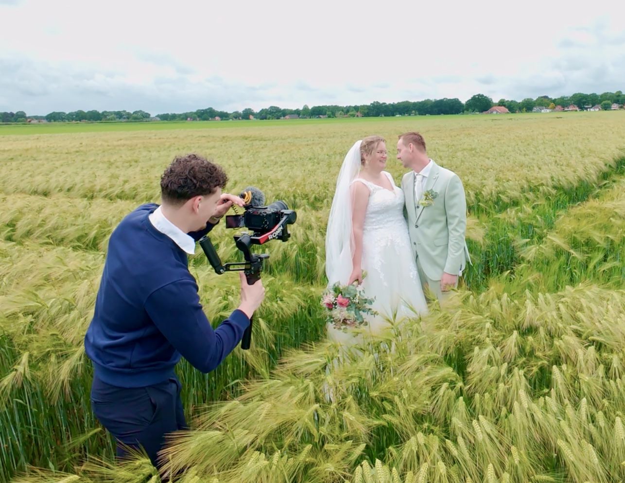 Trouwvideograaf Frank Timmer filmt een bruidspaar in een korenveld in Drenthe
